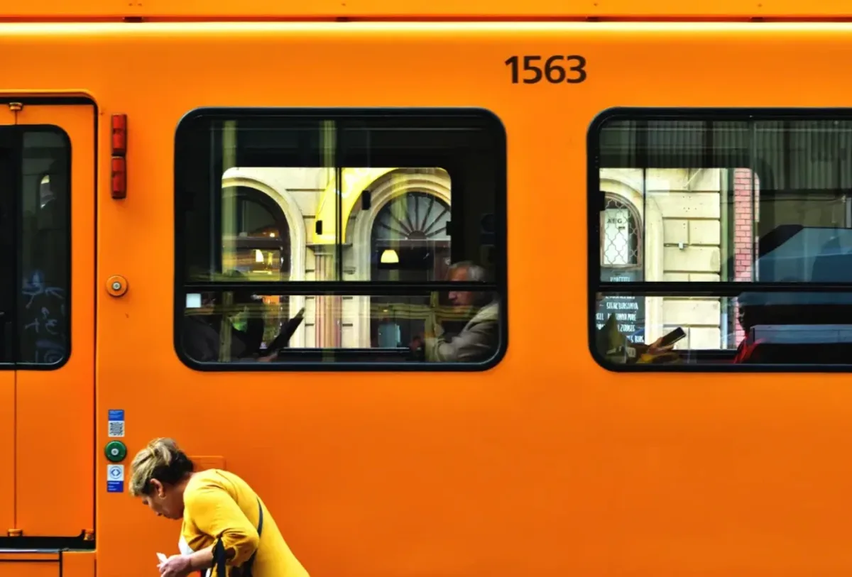 Pomarańczowy tramwaj i przechodzień